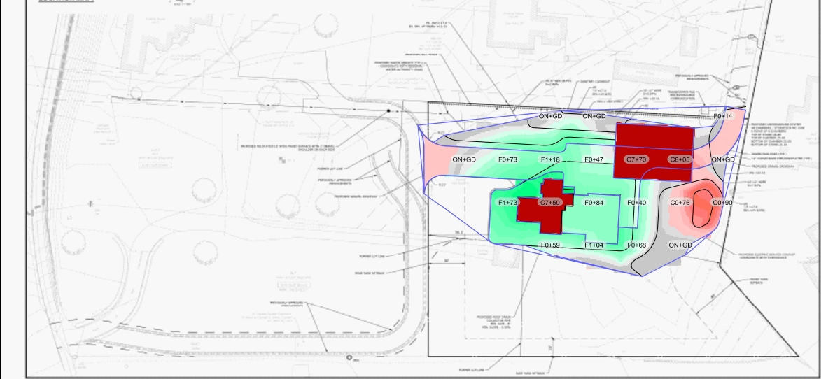 Topographic contour plan showing grading levels, flow directions, and drainage zones around the proposed building with elevation labels and color-coded slope areas.