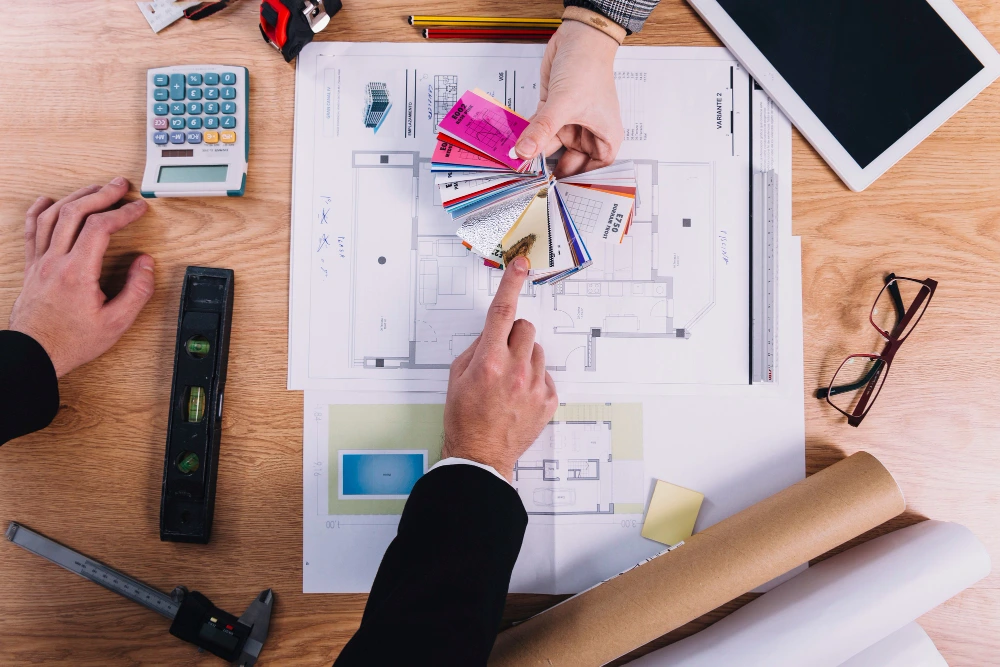 Retail fit-out planning with architectural blueprints, material swatches, and calculator for budget estimation
