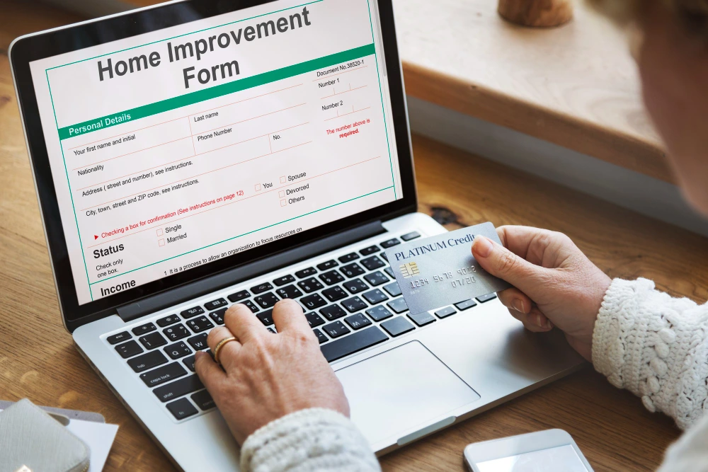 Person filling out home improvement form on laptop while holding platinum credit card for online payment- Excel for Home Construction Estimates Smart or Risky