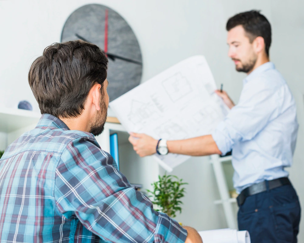 Construction professionals reviewing architectural plans and blueprints during owner consultation before starting building project-Every Owner Mind Before Construction
