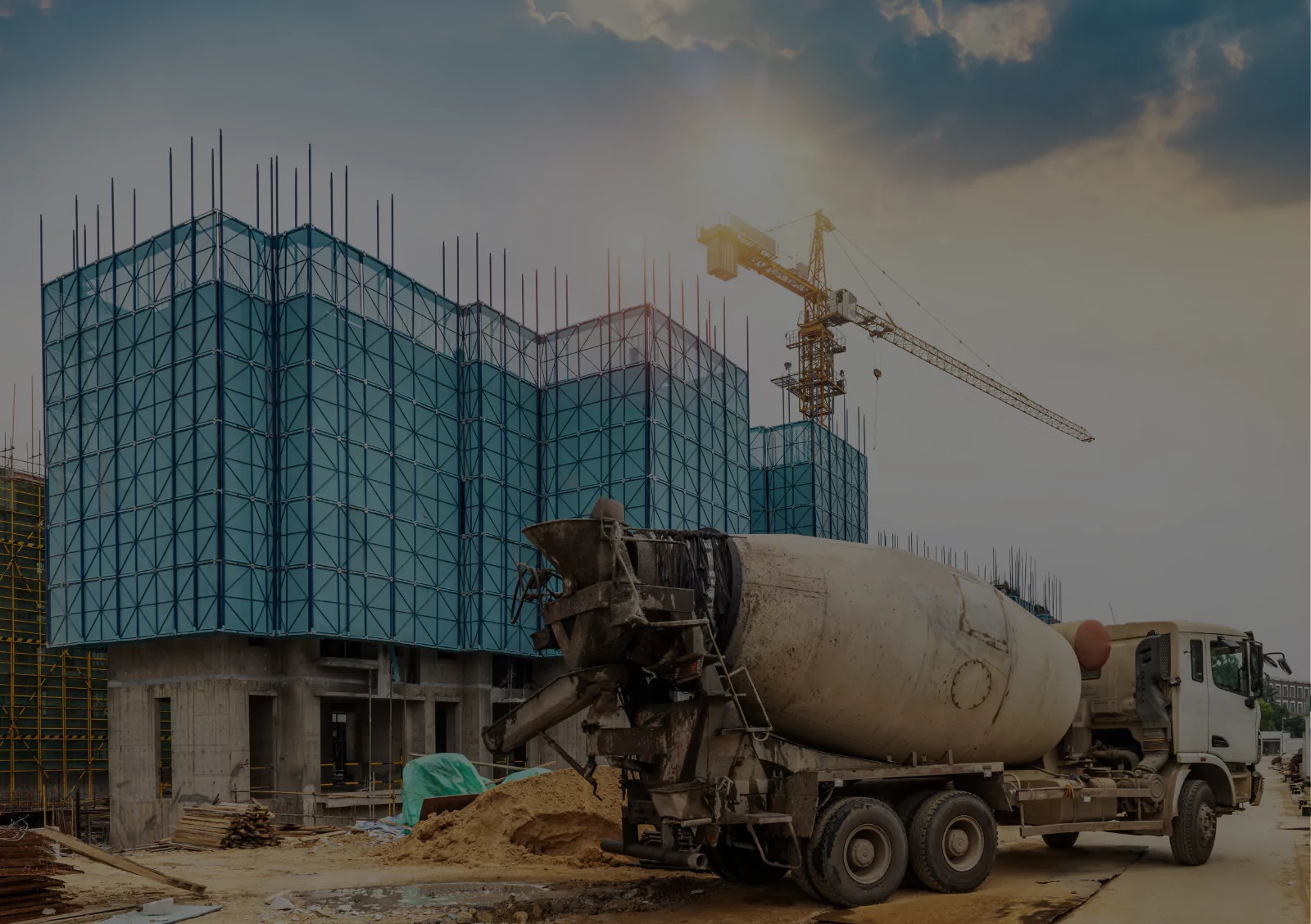 Construction site with a concrete mixer truck and a crane, showcasing the building process of a modern structure