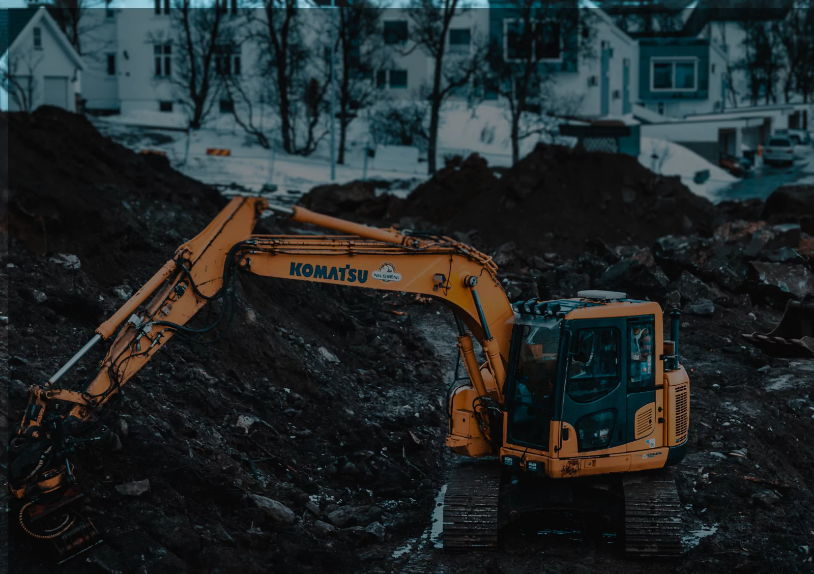 Komatsu excavator performing site excavation work in residential area for earthwork and grading cost estimates