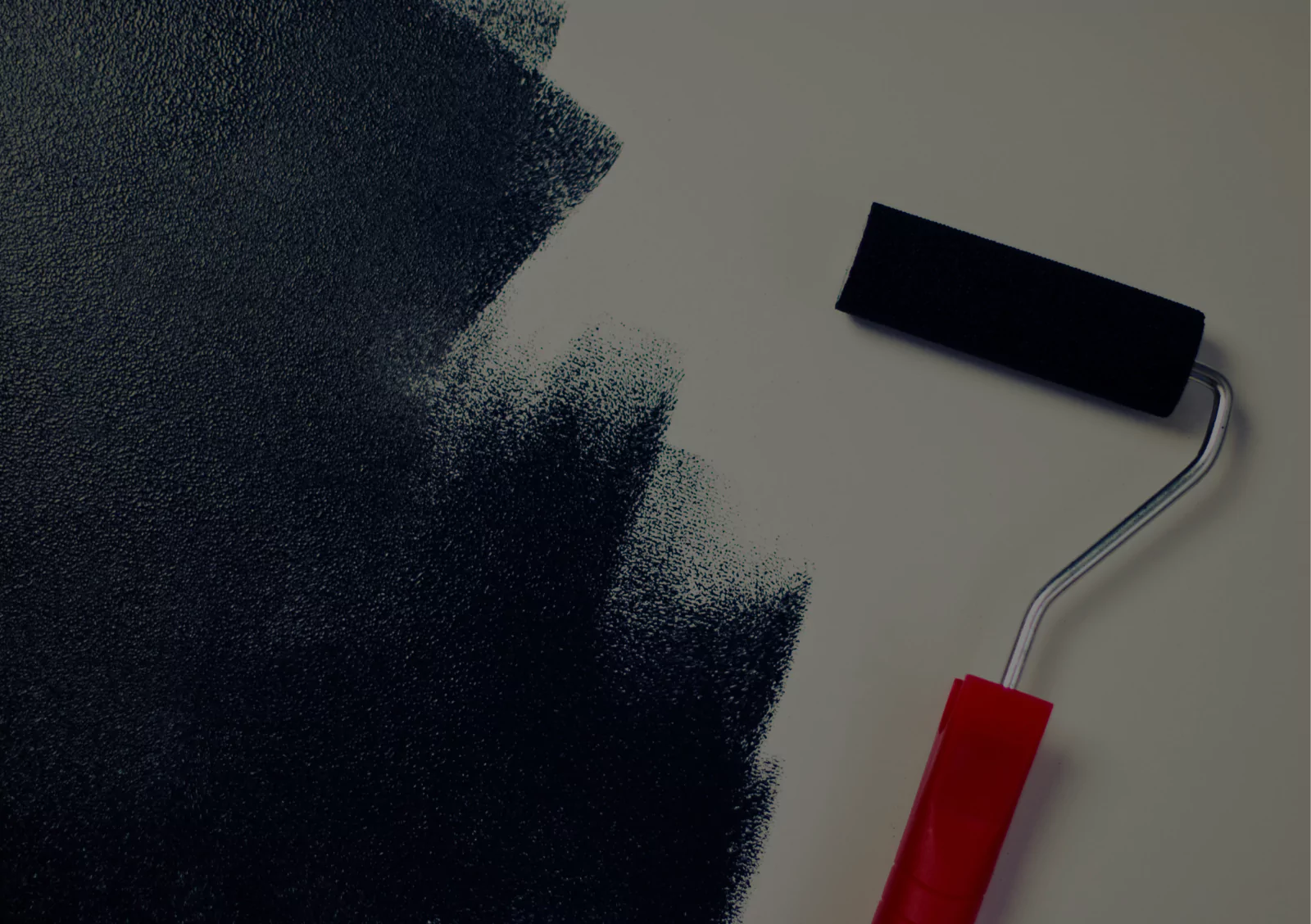 Paint roller applying dark paint to wall surface for interior painting project cost calculation