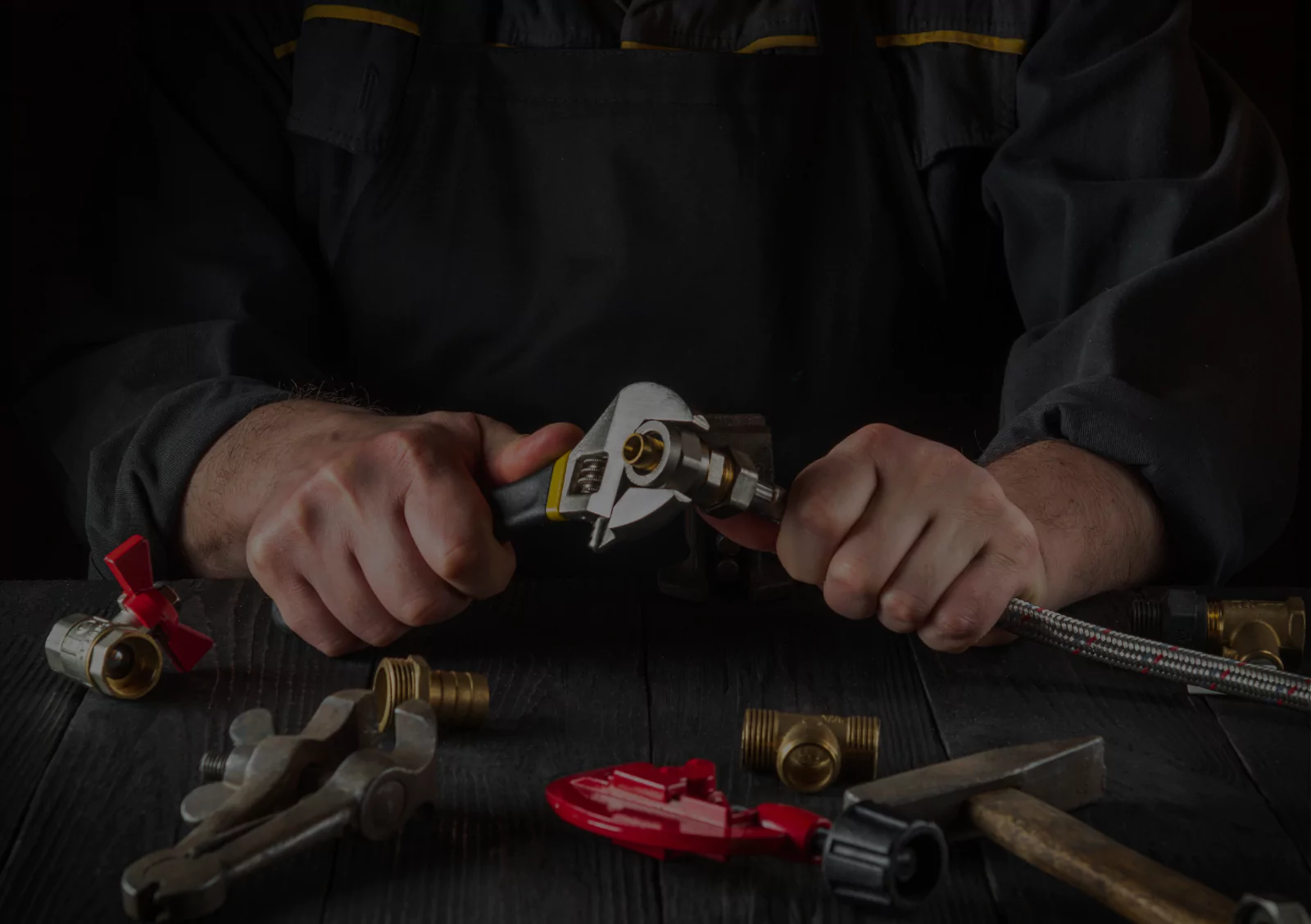 Plumber's hands assembling brass fittings and valves with professional plumbing tools for installation estimate